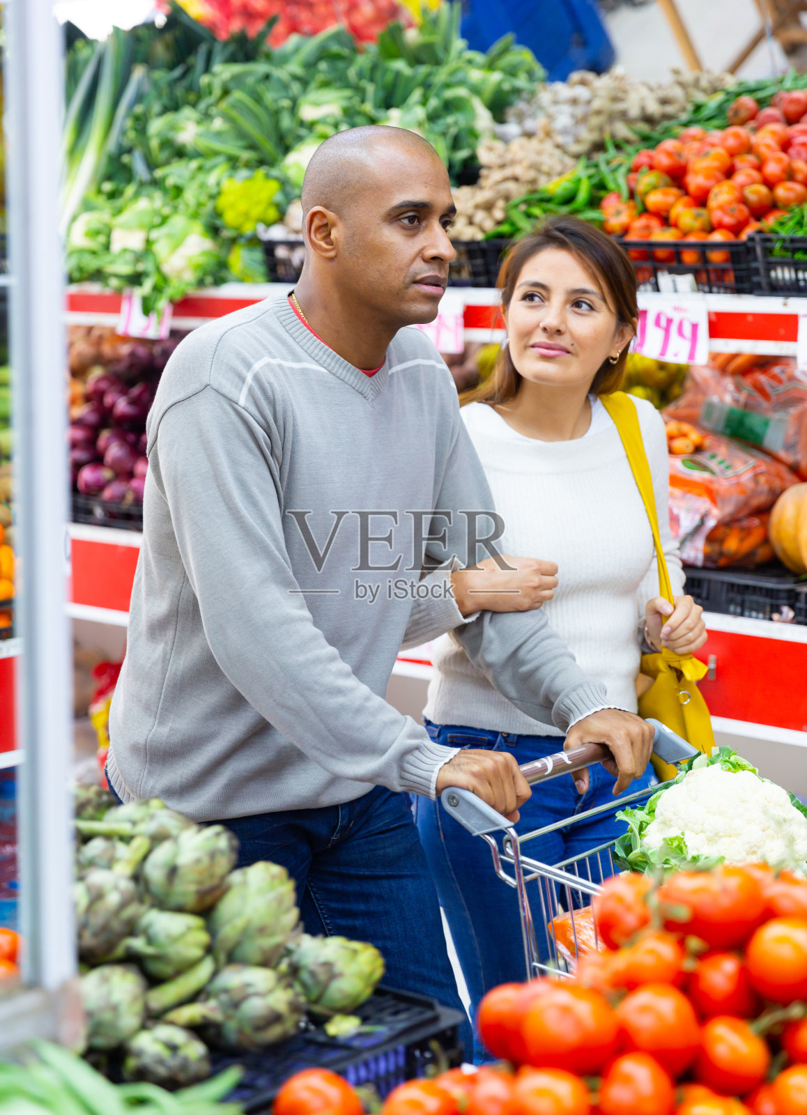 丈夫和妻子一起在超市里推着蔬菜和水果的车照片摄影图片