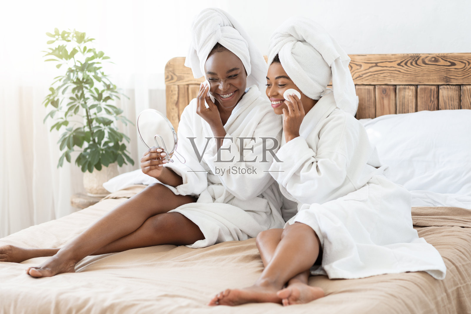 非裔美国女性朋友穿着浴袍在家里洗脸照片摄影图片