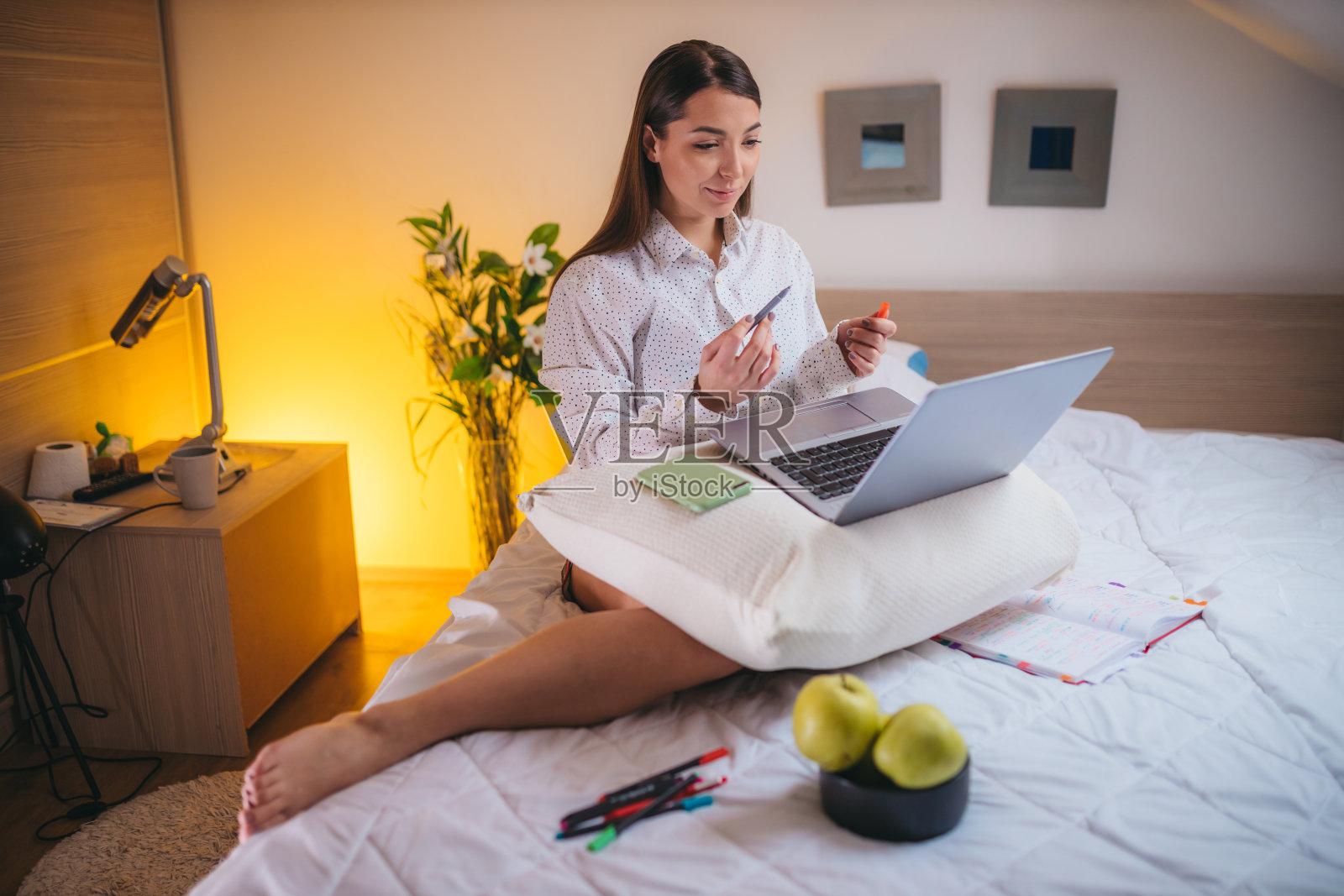 年轻女子坐在床上用笔记本电脑视频通话照片摄影图片