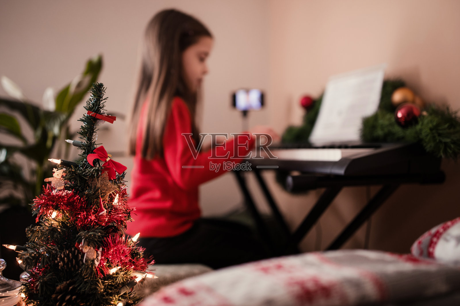 圣诞节期间在家弹钢琴的女孩照片摄影图片