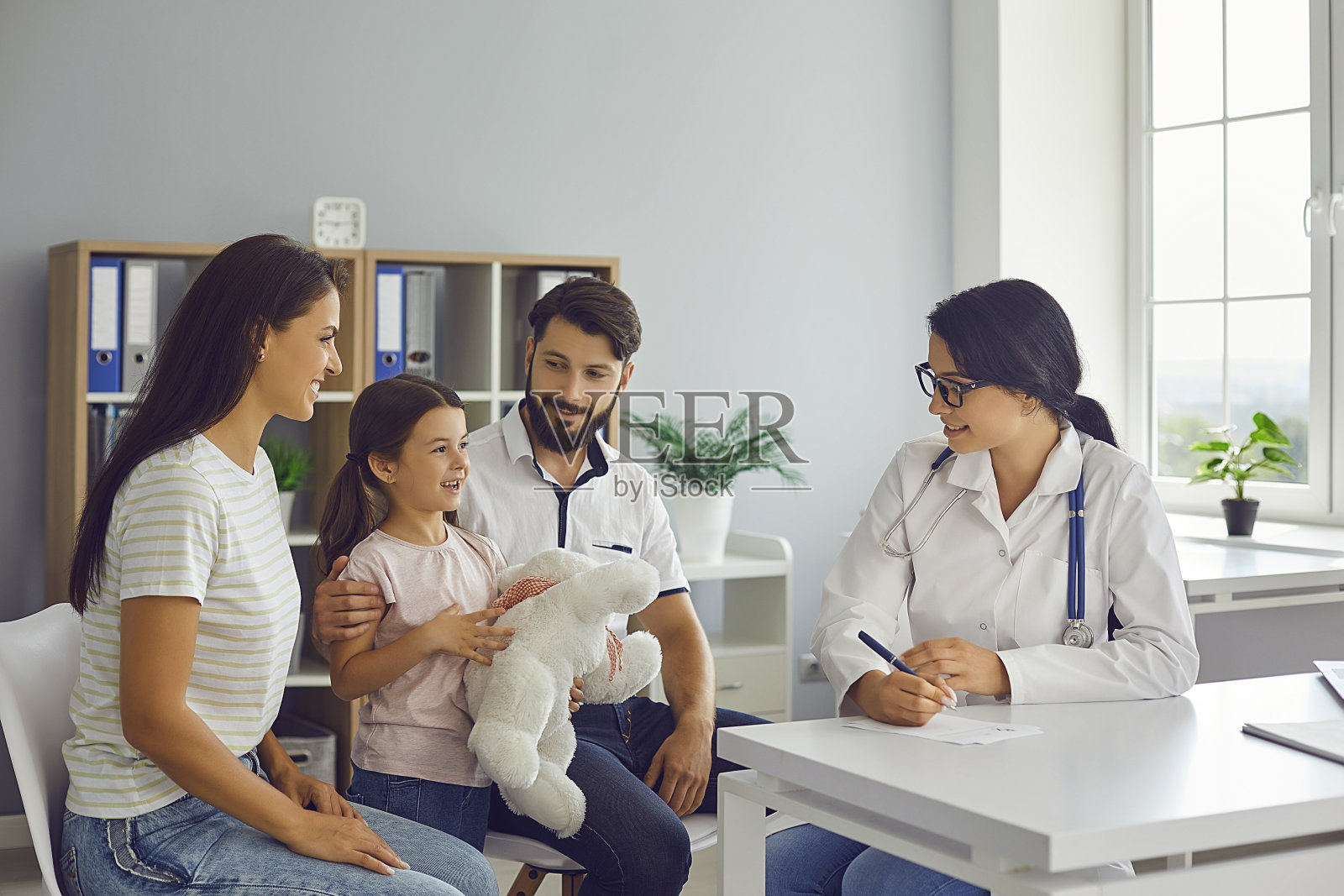 幸福家庭在现代儿科医生的办公室里咨询友好的年轻女医生照片摄影图片