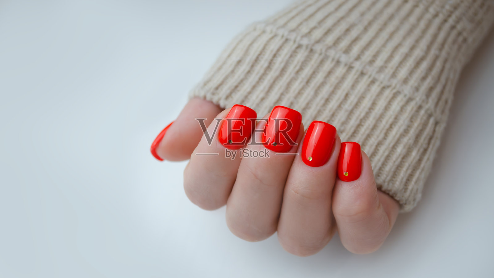 一个年轻女人的手。指甲上涂着红色的指甲油。修指甲的想法。照片摄影图片