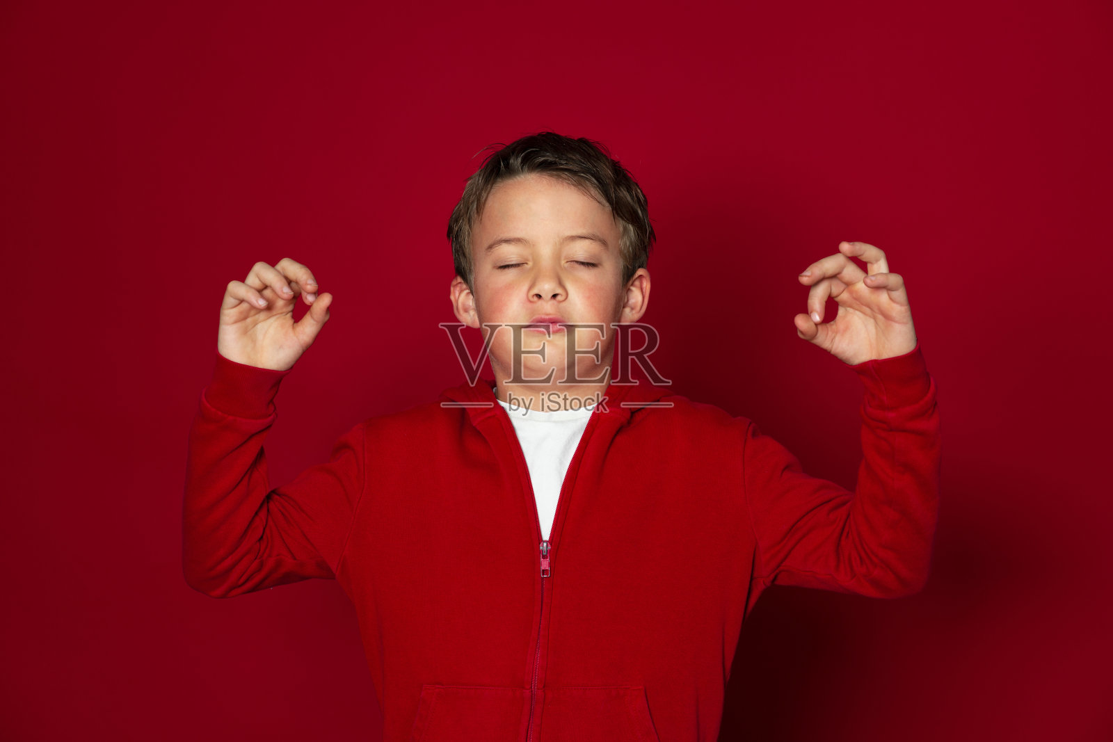 帅气的小男孩在红色背景前摆姿势照片摄影图片