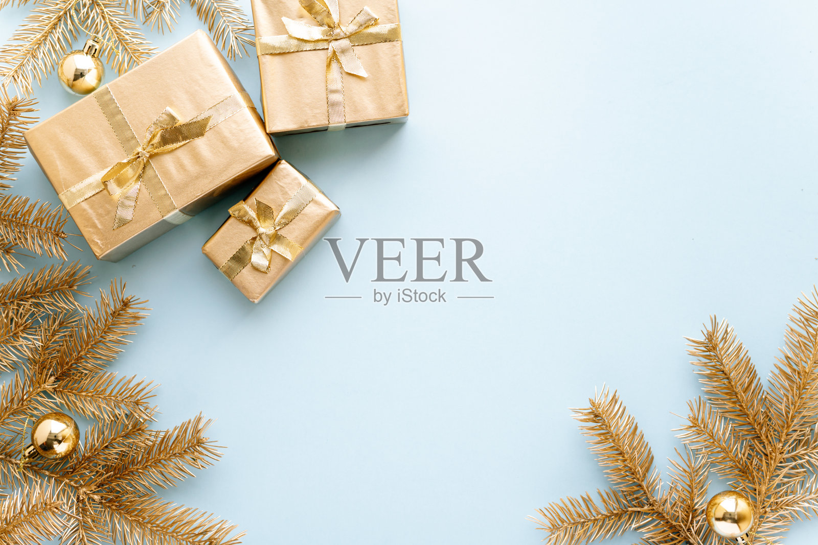 蓝色的圣诞或新年背景，素朴的金色圣诞礼物和金杉枝与圣诞玩具，Flatlay，空白的问候文字。圣诞节的概念。照片摄影图片