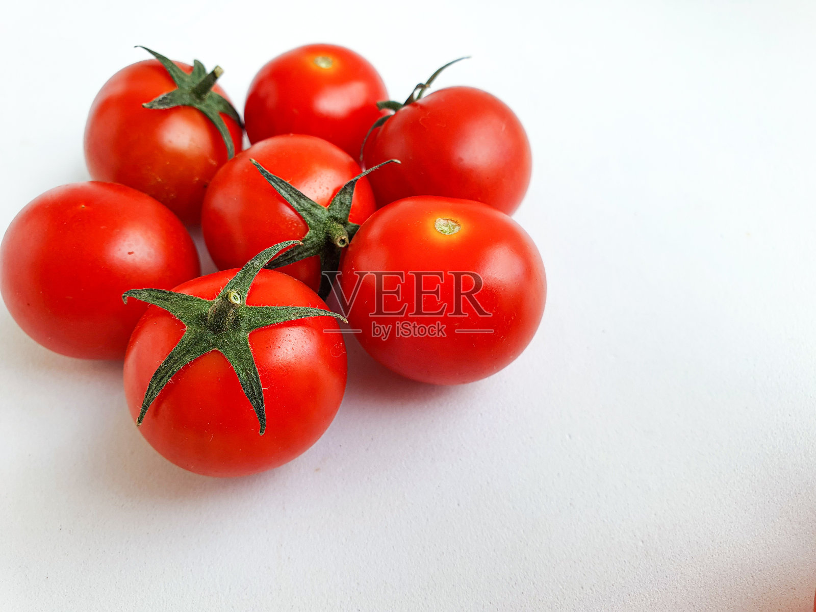 白色背景上的新鲜小樱桃番茄。新鲜的蔬菜照片摄影图片