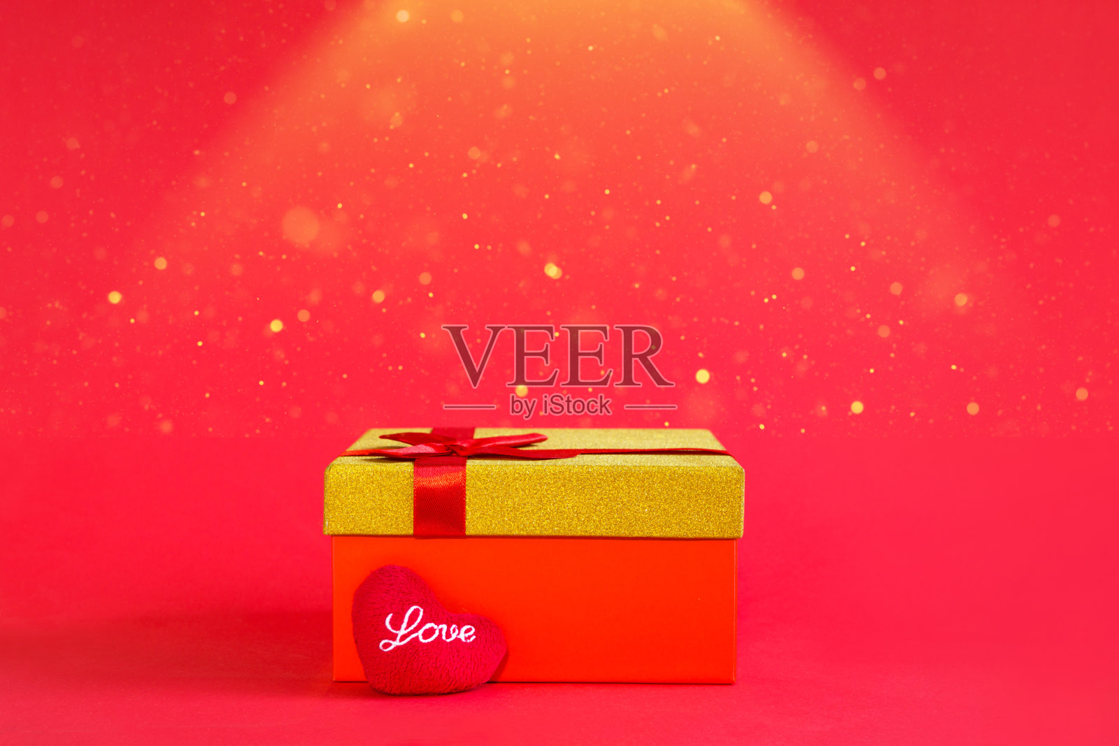 打开红色礼盒与一个蝴蝶结和柔软的心与爱在金色的光芒和闪闪发光在红色的背景，横幅，copyspace里面。四海假日、情人节、新年、生日照片摄影图片