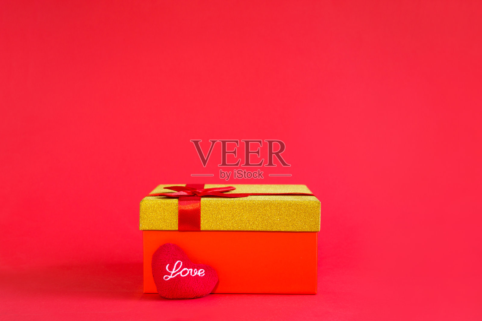 打开红色礼盒与一个蝴蝶结和柔软的心与爱在金色的光芒和闪闪发光在红色的背景，横幅，copyspace里面。四海假日、情人节、新年、生日照片摄影图片
