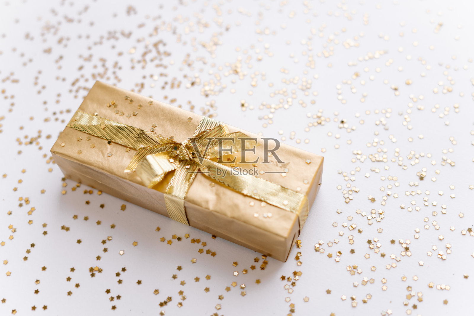 白色的圣诞或新年的背景，素朴的组成金色圣诞礼物与金色的星星。Flatlay，空白的问候文字。圣诞节的概念。照片摄影图片