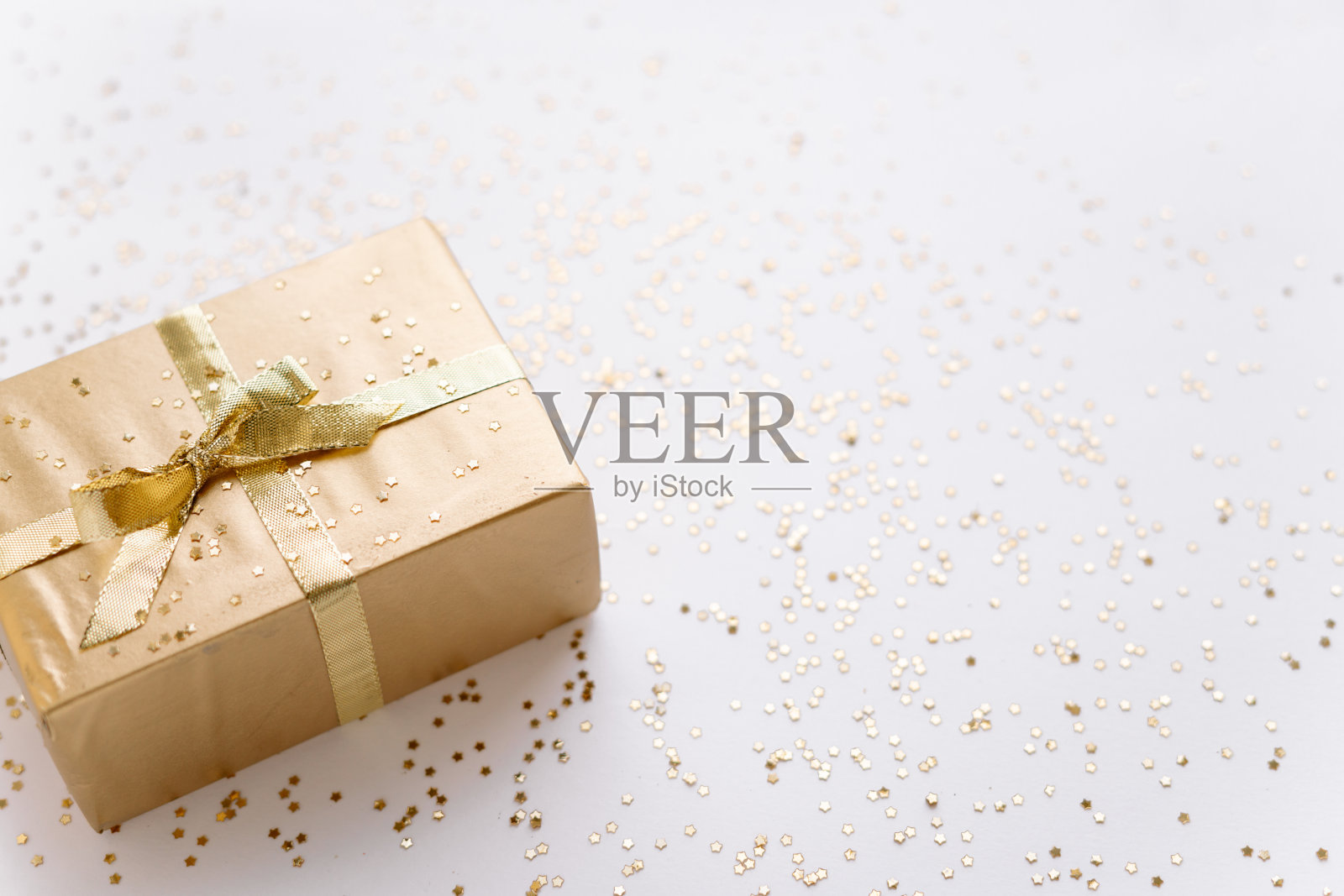 白色的圣诞或新年的背景，素朴的组成金色圣诞礼物与金色的星星。Flatlay，空白的问候文字。圣诞节的概念。照片摄影图片