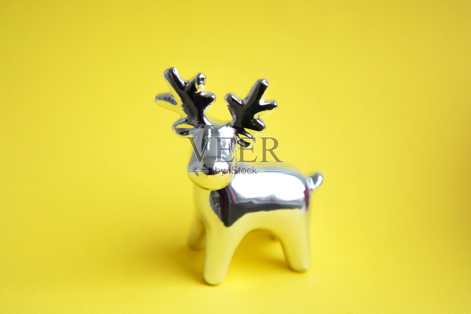 新年闪亮的玩具鹿在明亮的黄色背景上照片摄影图片
