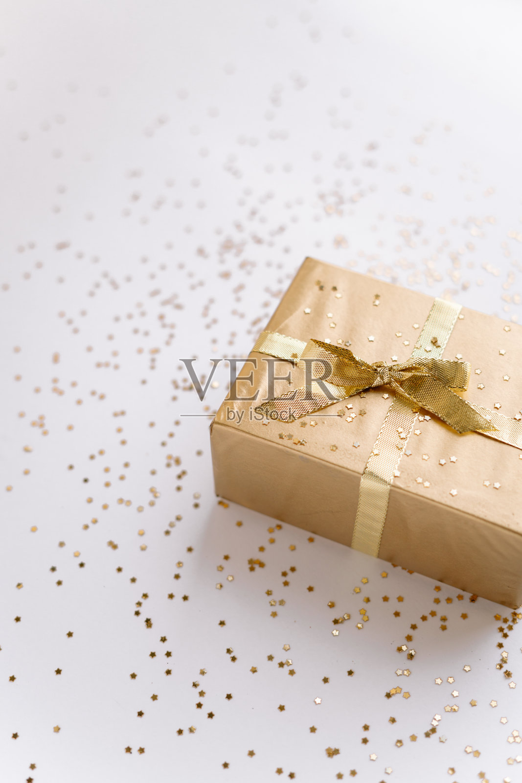 白色的圣诞或新年的背景，素朴的组成金色圣诞礼物与金色的星星。Flatlay，空白的问候文字。圣诞节的概念。照片摄影图片