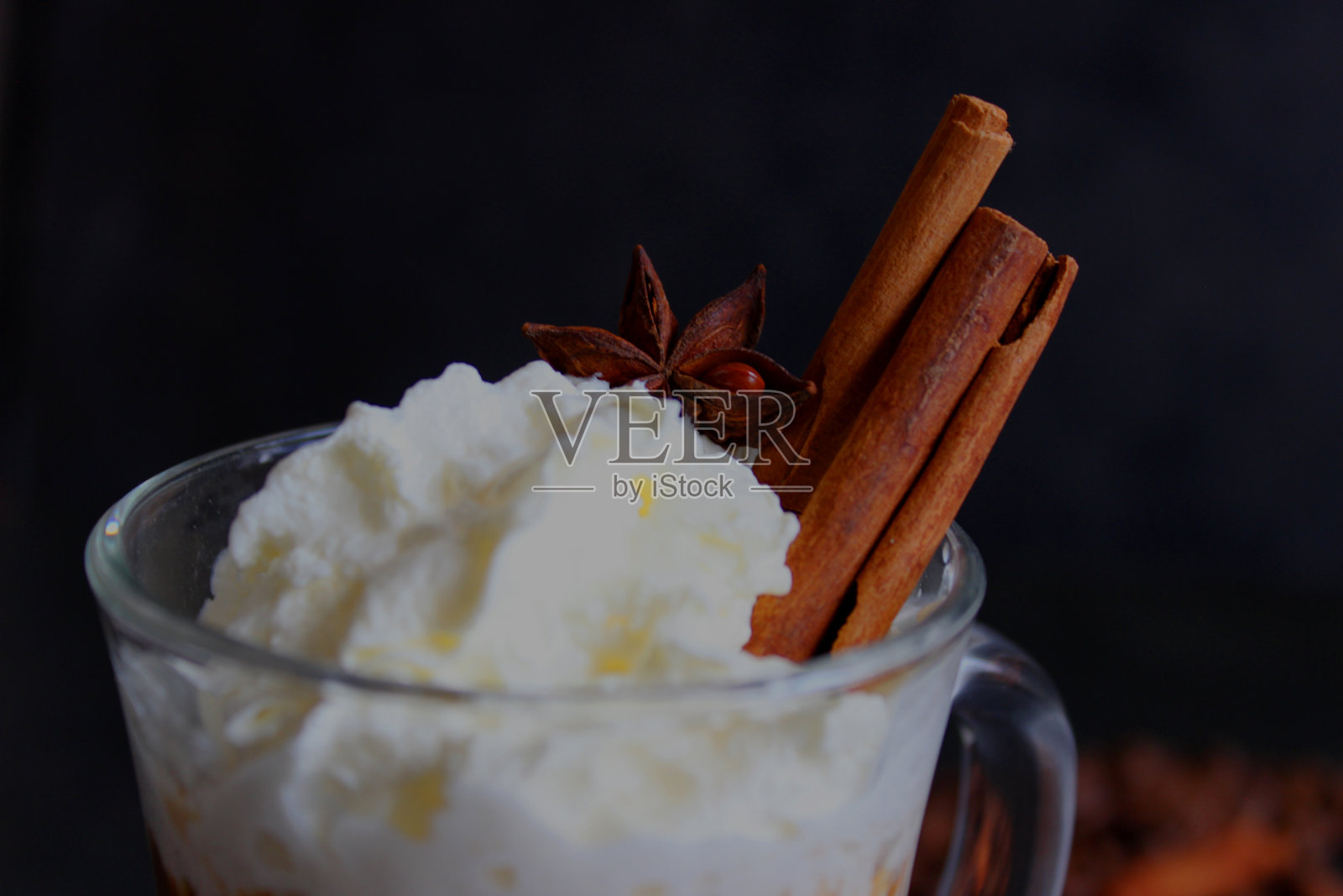 泡沫咖啡饮料。卡布奇诺或拿铁在一个透明的玻璃在黑暗的背景。照片摄影图片