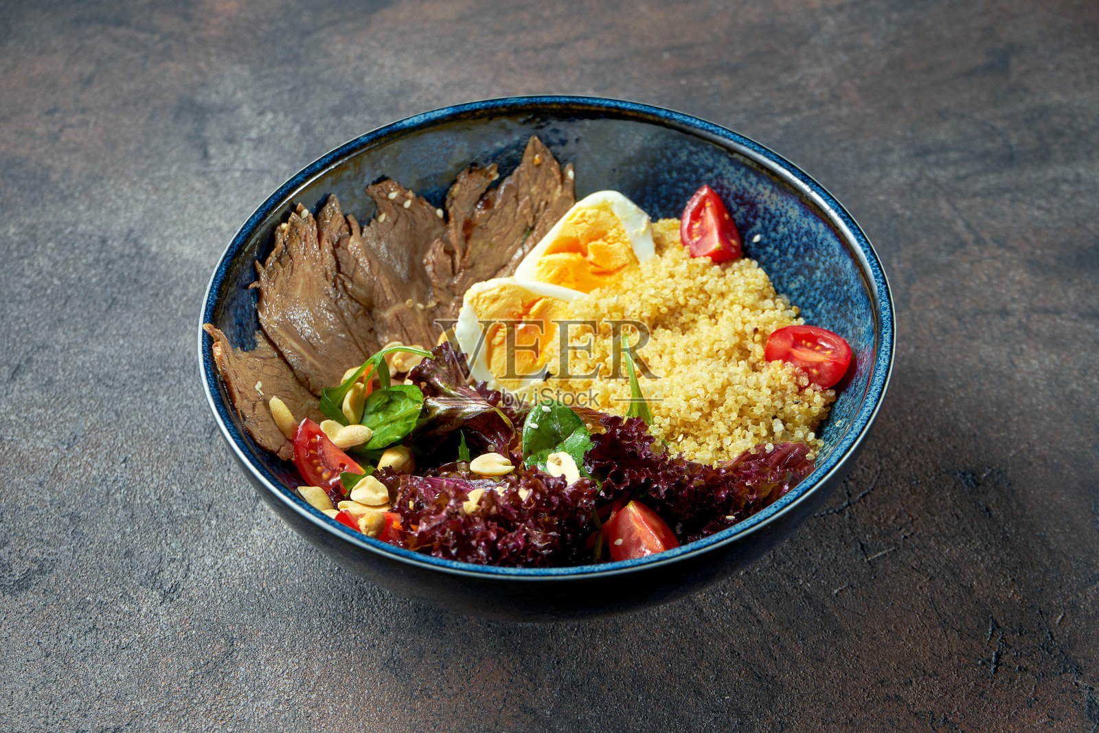 佛碗配烤牛肉，蒸粗麦粉，西红柿和鸡蛋在一个蓝色的盘子里。照片摄影图片