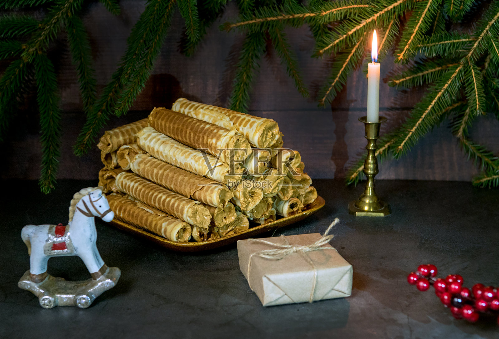 圣诞华夫饼——在圣诞背景上放奶油的盒子。圣诞彩灯的节日气氛。圣诞背景与糖果。礼物。甜蜜的华夫饼干甜点照片摄影图片