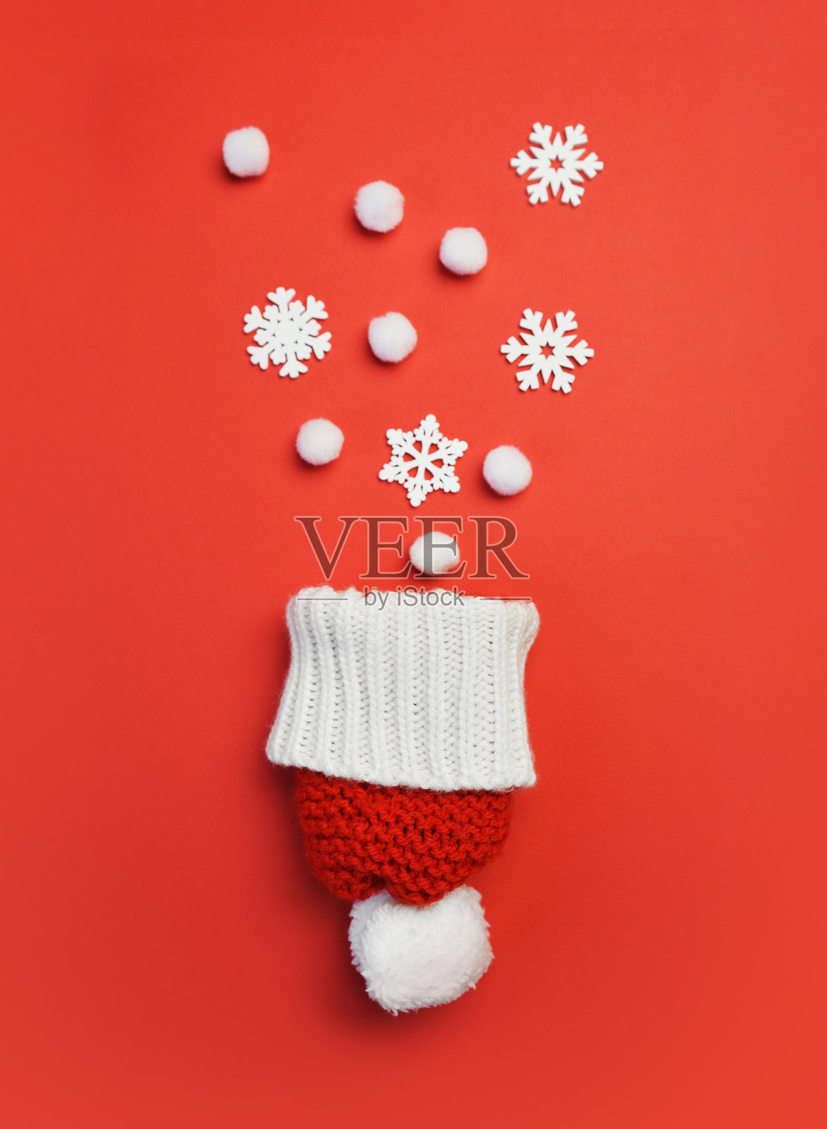 圣诞贺卡与红帽和雪花在红色的背景。圣诞假期明信片与地方为你的文字。冬天新年快乐照片摄影图片