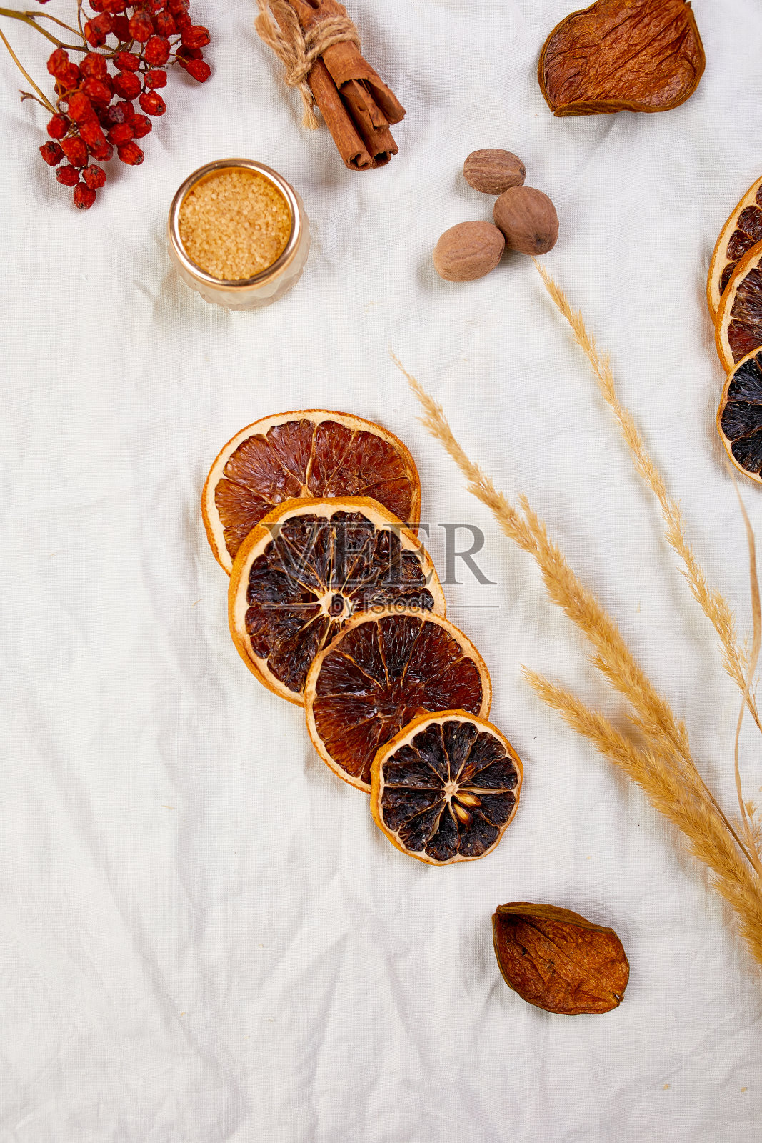 平铺配料和一瓶红葡萄酒为冬季季节热葡萄酒在白色纺织亚麻桌布上，静物，布料纹理背景，圣诞饮料，复制空间。照片摄影图片