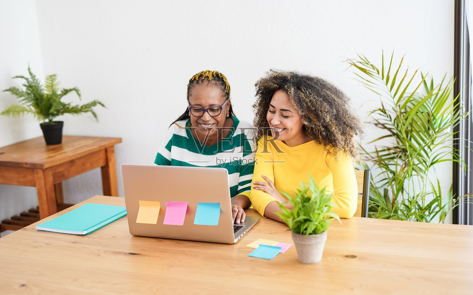 非洲的老年母亲和成年的女儿在家里一起看笔记本电脑照片摄影图片