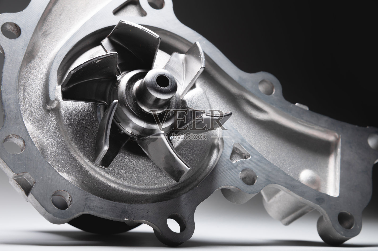 ICE液体冷却泵。发动机冷却液泵。在灰色背景上对比光线照片摄影图片