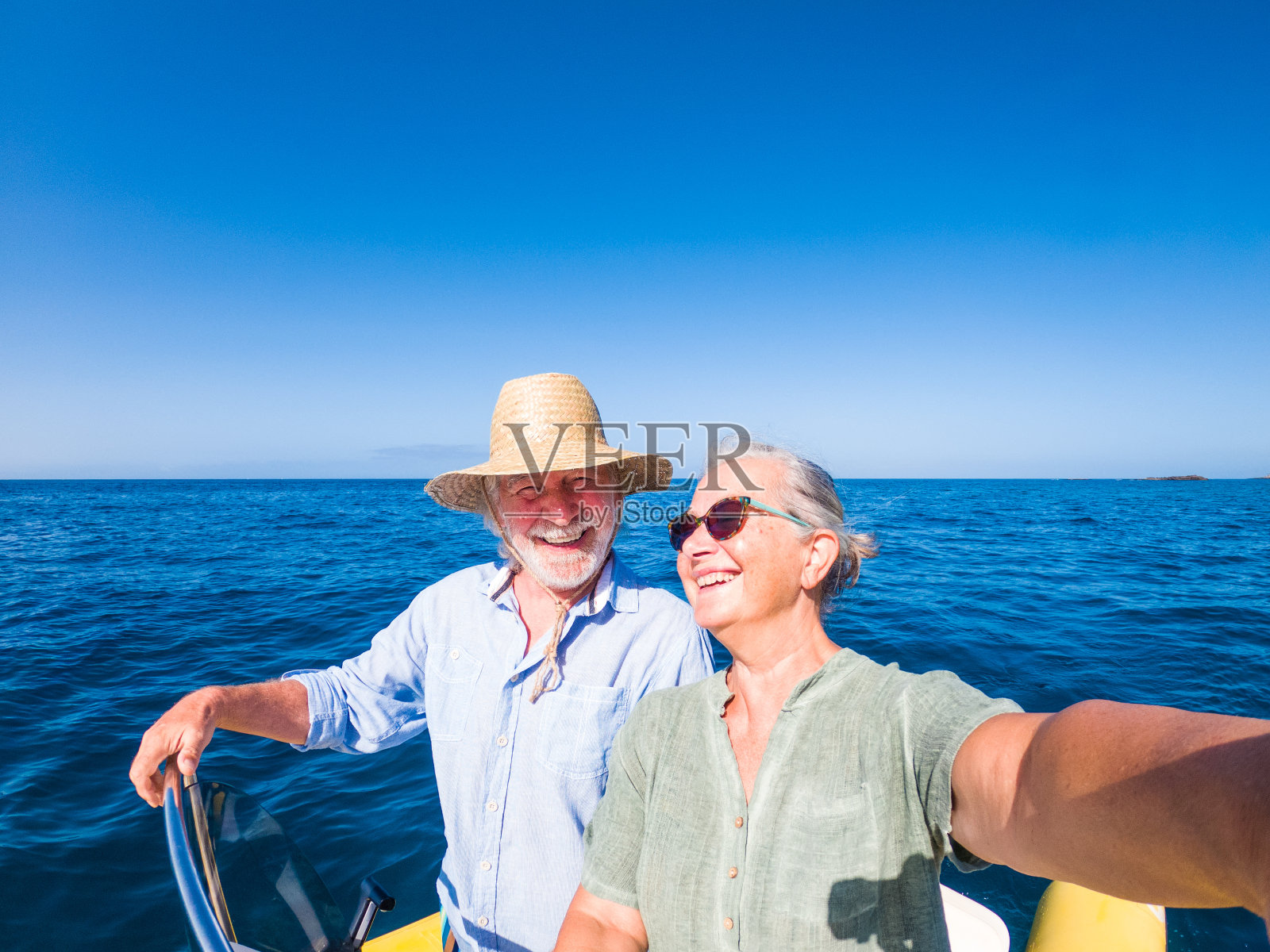 一对可爱的成熟的人或老年人享受和玩在一起在海或海洋的小船或小艇-妇女养老金与她的老人驾驶的船自拍照片摄影图片