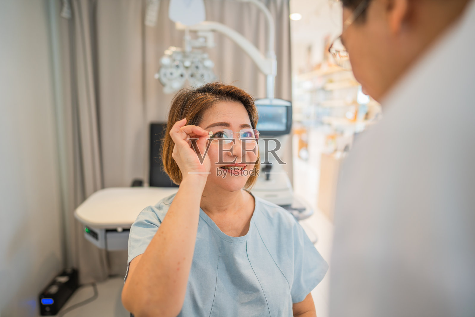 一位亚洲女顾客在眼镜店试用她的新眼镜照片摄影图片