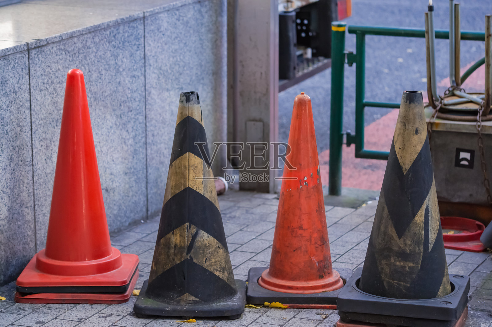 东京新宿繁华商业区人行道上的彩色锥状物。照片摄影图片