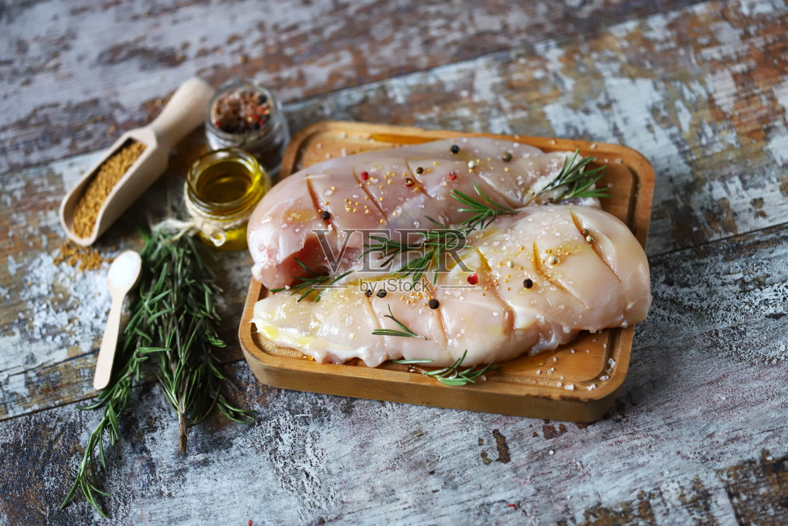 生鸡胸肉配迷迭香和香料。照片摄影图片