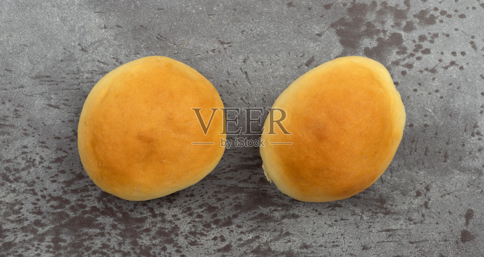 灰色背景上的两个自制酵母卷。照片摄影图片