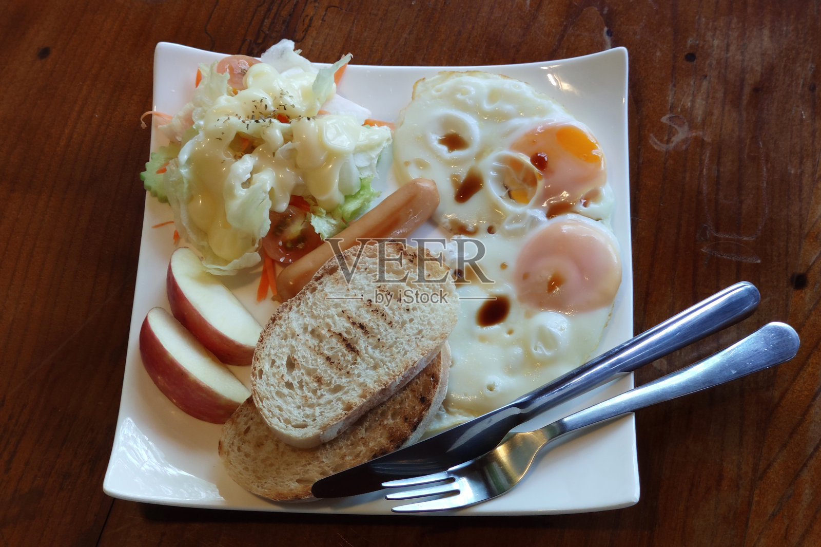 俯瞰自制的早餐，新鲜的热煎蛋，香肠，沙拉和烤面包在白色的盘子在木桌上，英国人，美国人Frühstück照片摄影图片