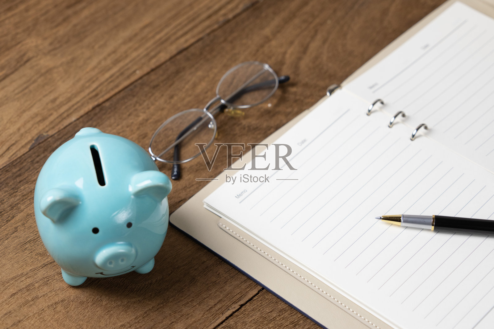 存钱罐和打开笔记本的概念在木桌上照片摄影图片