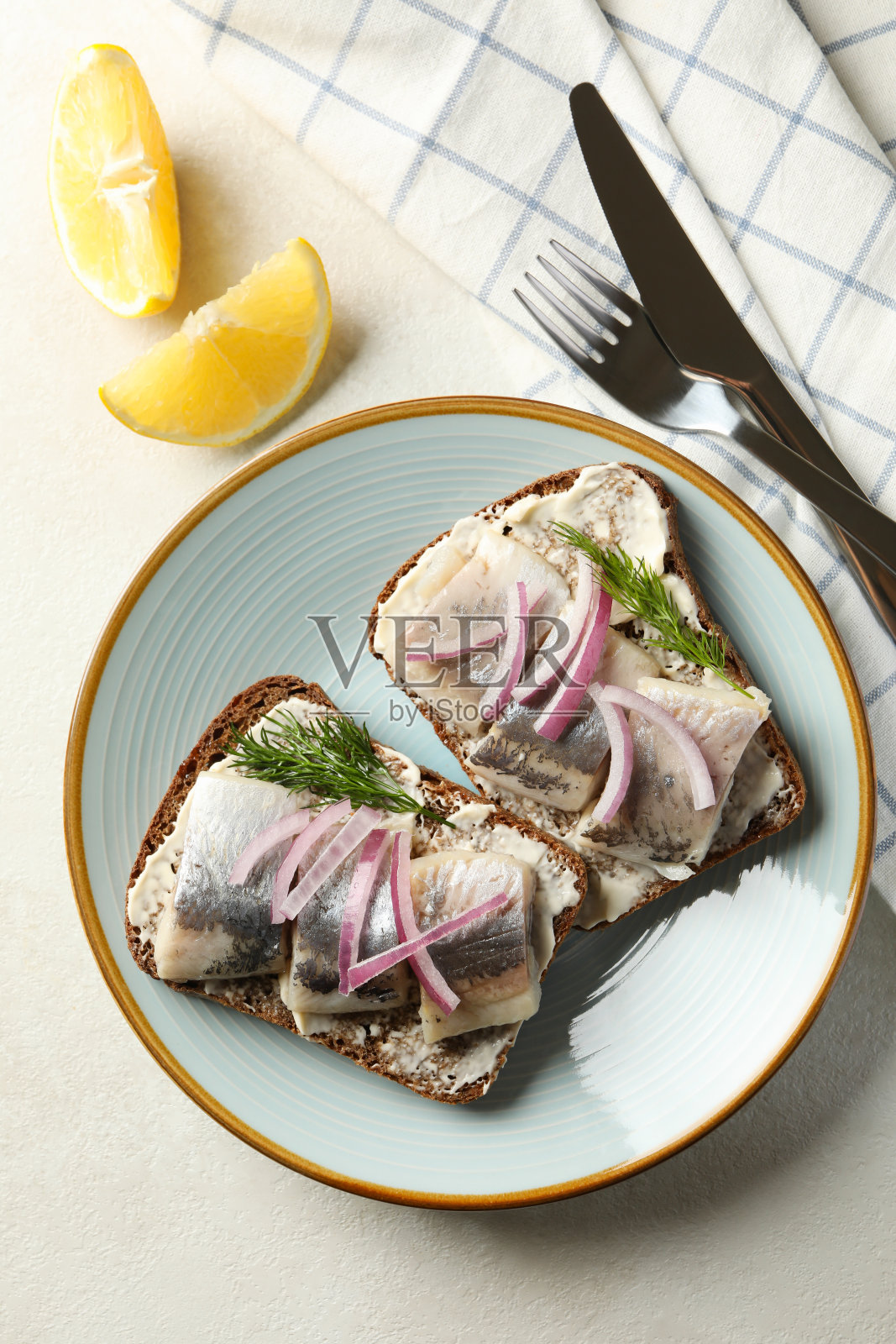 一盘带有新鲜鲱鱼的三明治，背景是白色的纹理照片摄影图片