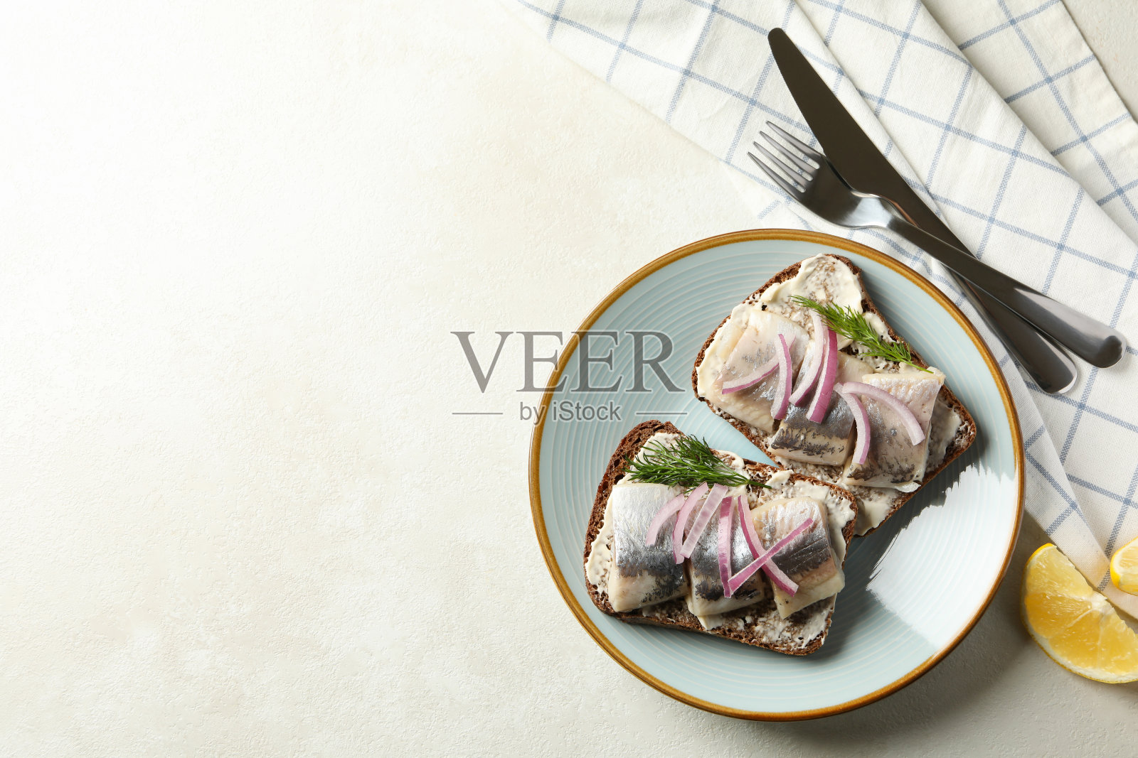 一盘带有新鲜鲱鱼的三明治，背景是白色的纹理照片摄影图片