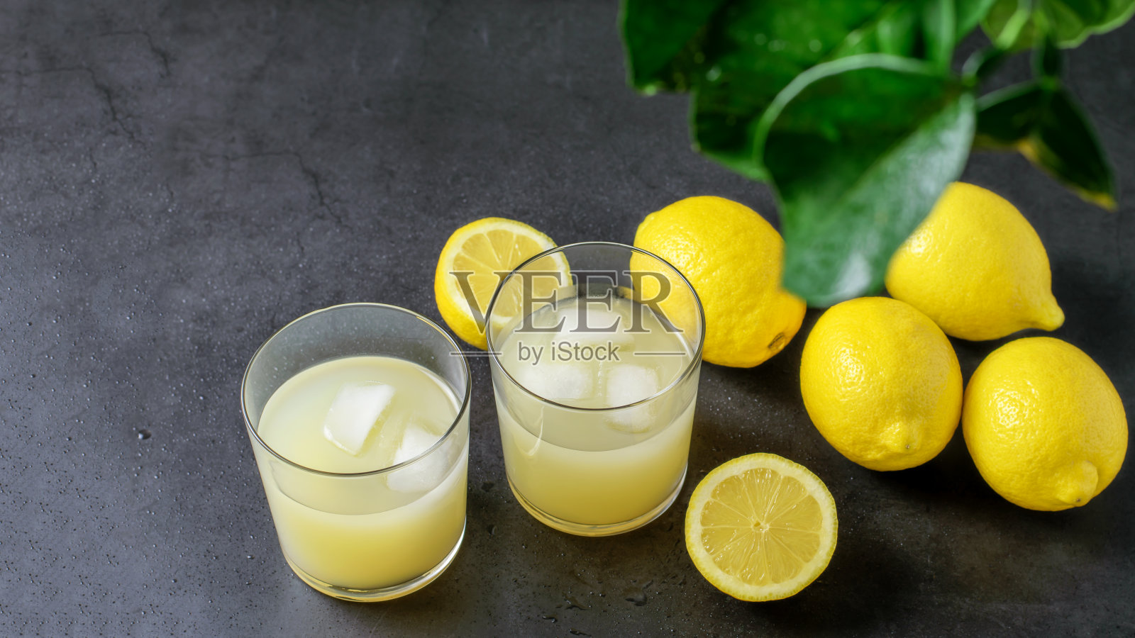 成熟的柠檬水果和新鲜的柠檬在灰色的背景。照片摄影图片