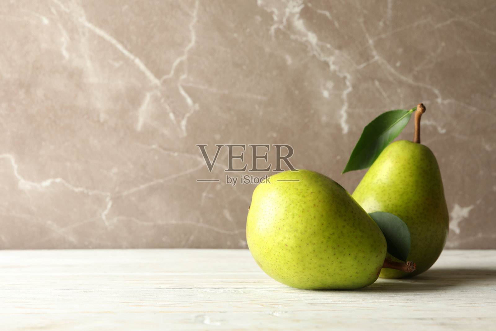 灰色背景的木桌上放着新鲜的绿色梨照片摄影图片