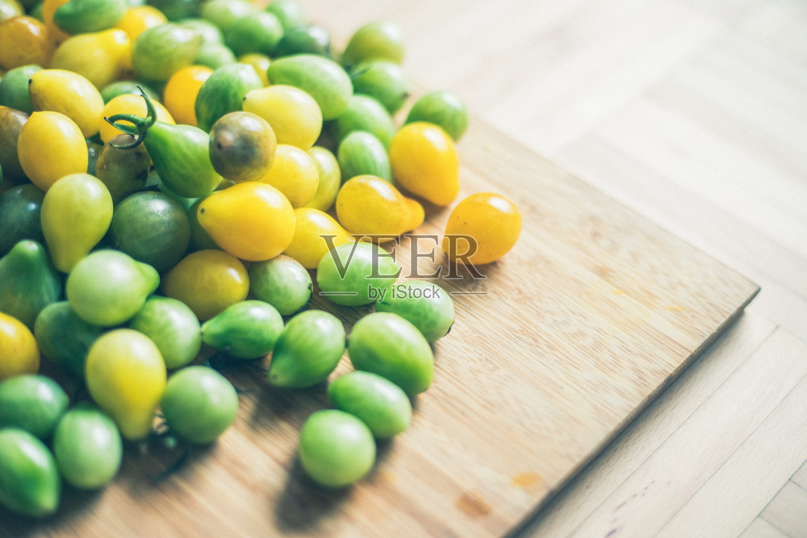 黄色和绿色的鸡尾酒西红柿放在竹板上，特写照片摄影图片