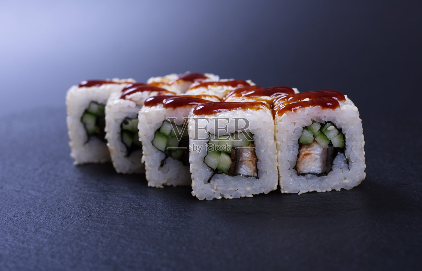 深色的石头背景上是五颜六色的海鲜卷和米饭照片摄影图片