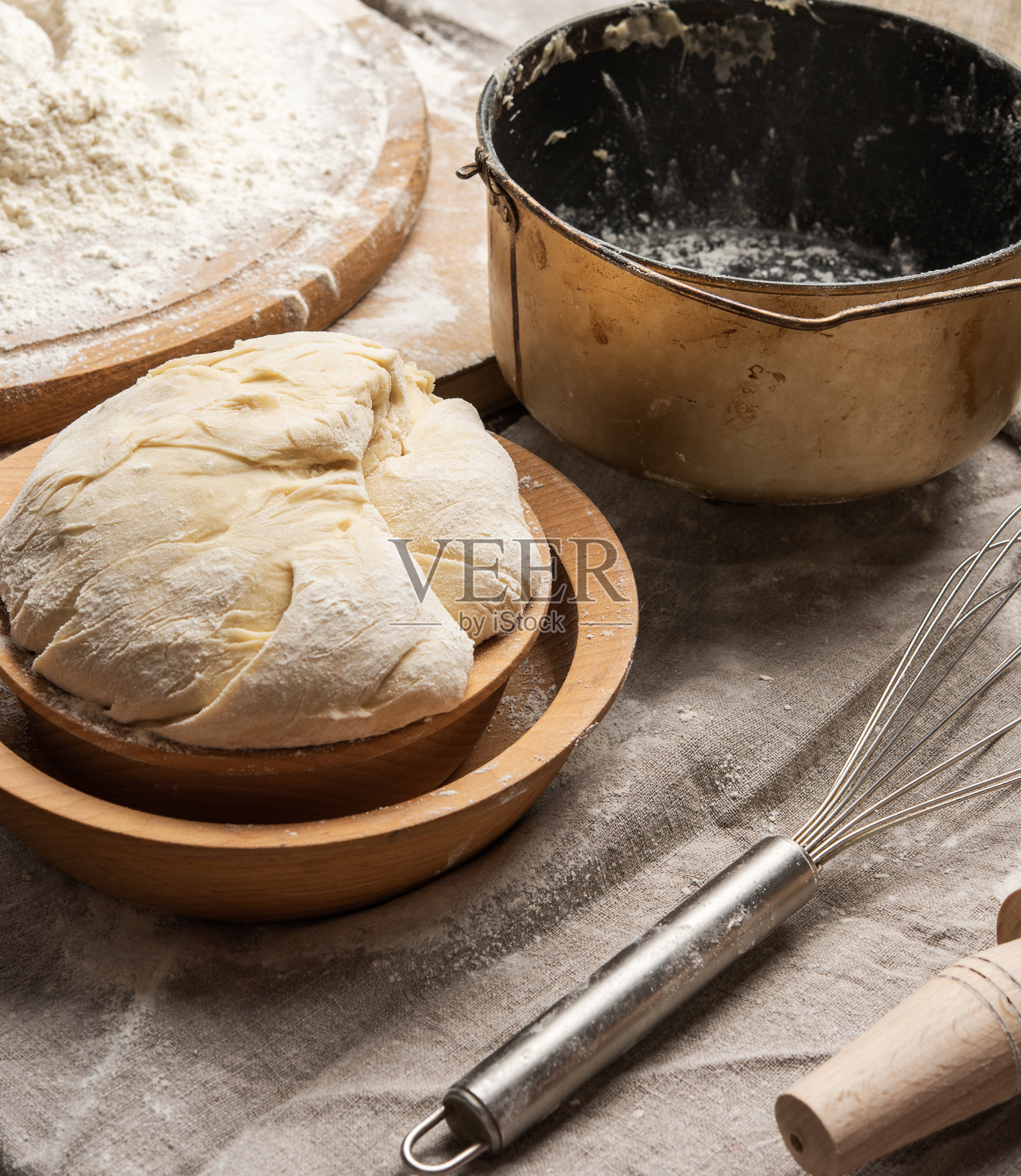 用白色小麦粉在一个木盘和一个金属揉面桶里揉成的面团照片摄影图片