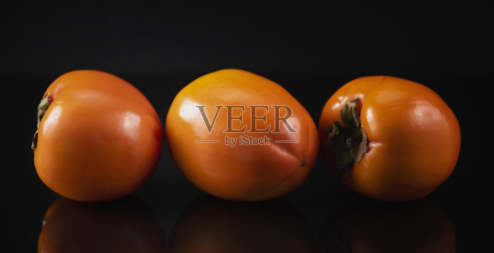 日本柿子的黑色背景与反射照片摄影图片