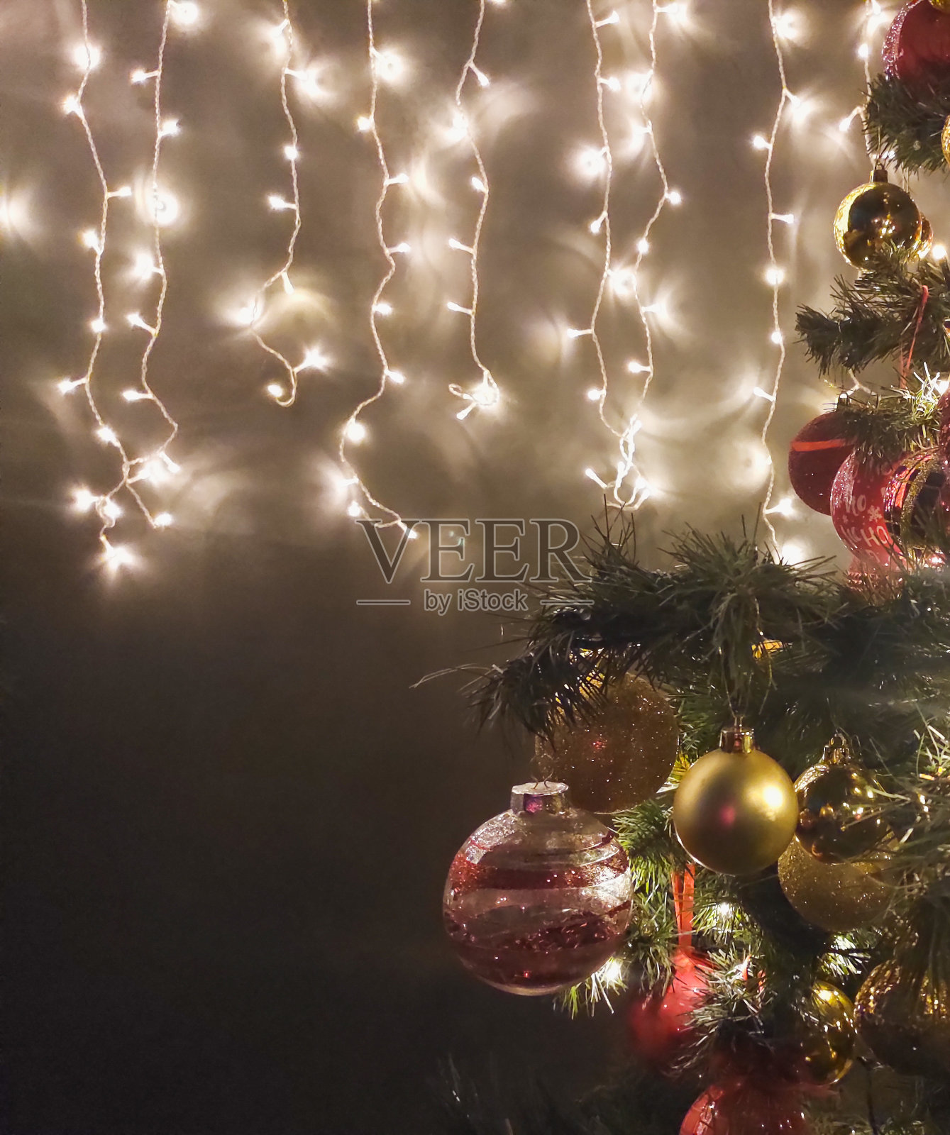 圣诞树在黑暗中装饰，墙上挂着花环照片摄影图片