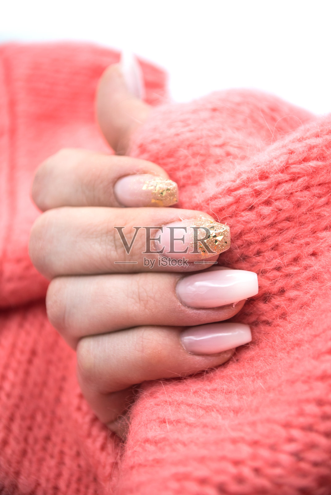 手的女人与美丽的指甲在粉红色套衫背景照片摄影图片