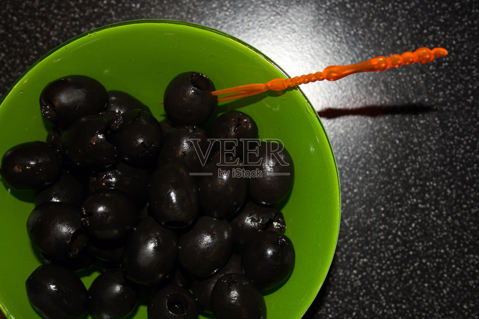 绿碗里的黑橄榄。零食。照片摄影图片
