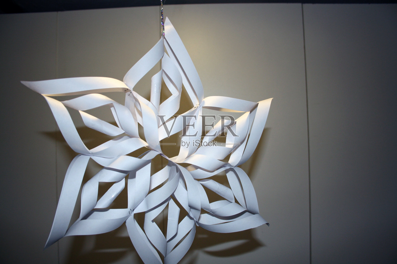 圣诞节的雪花是白纸做的。照片摄影图片