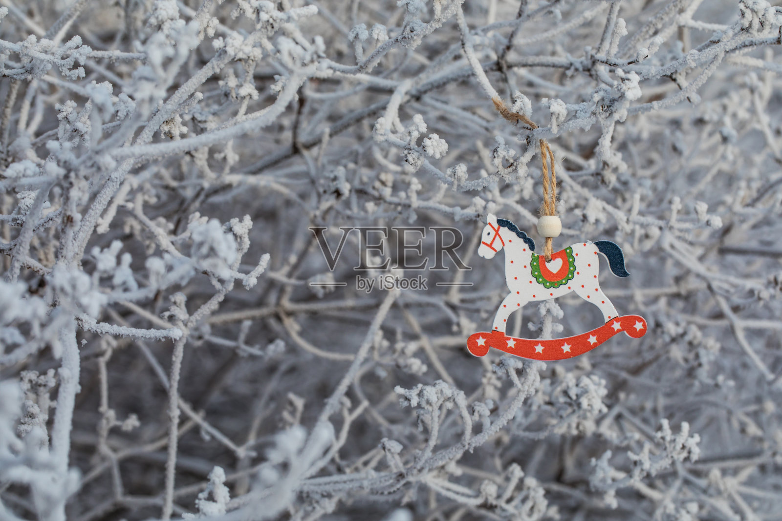 新年的玩具——木马摇在树枝上。照片摄影图片