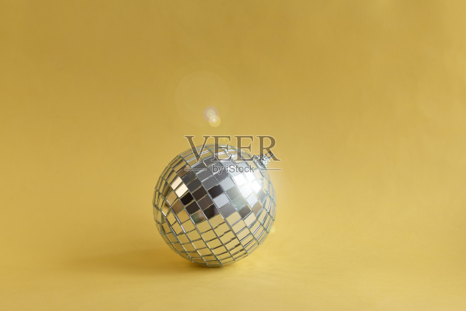 黄色背景上的迪斯科球照片摄影图片