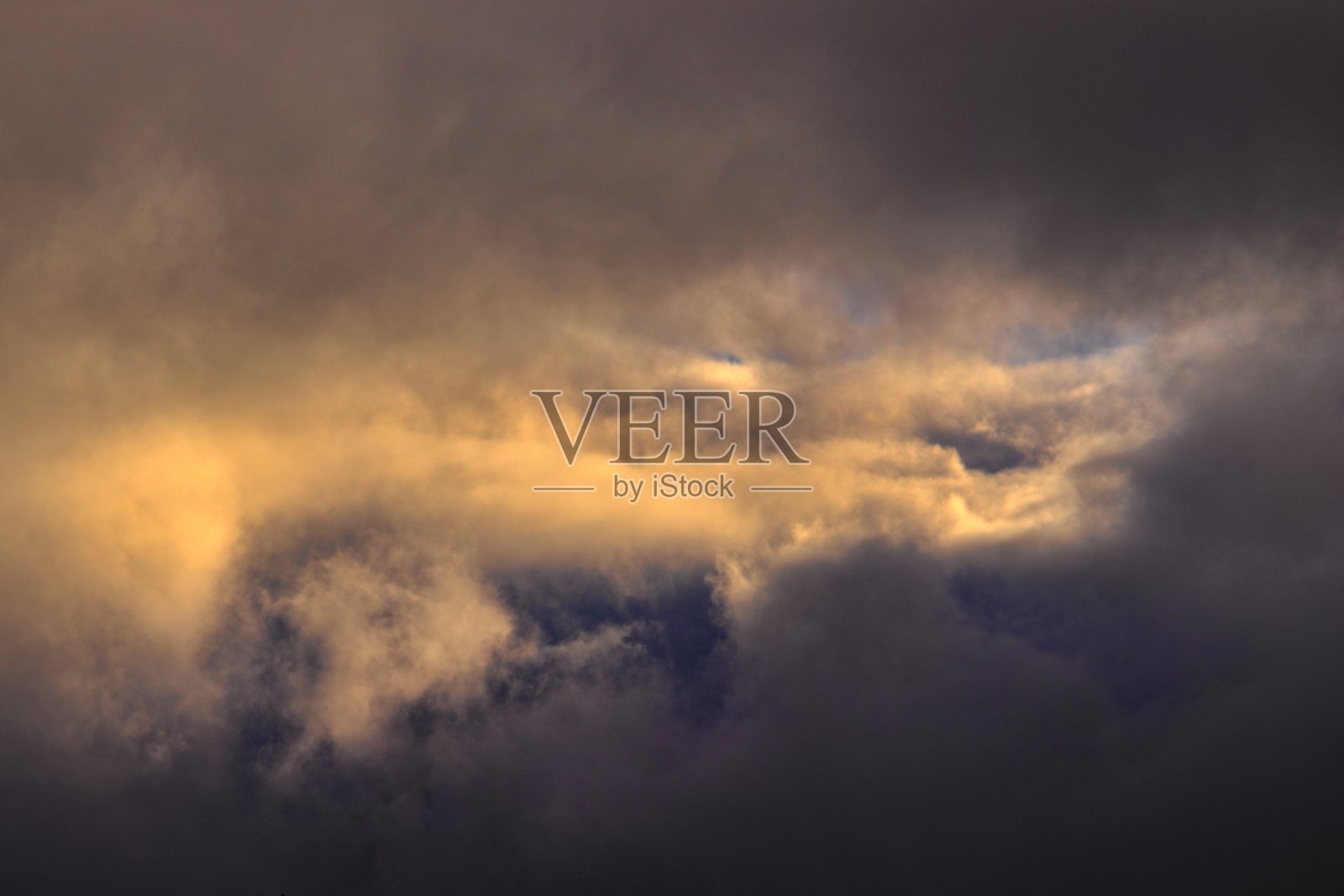 戏剧性的天空与乌云包围了一片蓝天与云被傍晚的光。照片摄影图片