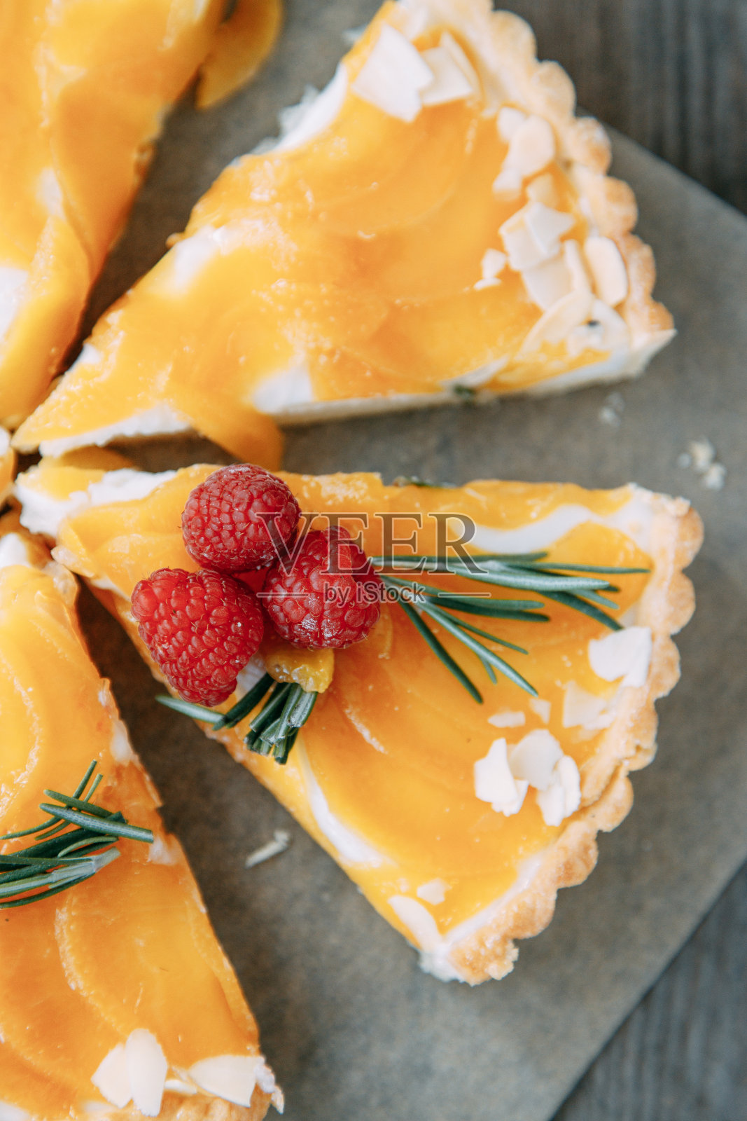 木制背景上的柠檬柑橘派。特写的一片柠檬派。照片摄影图片