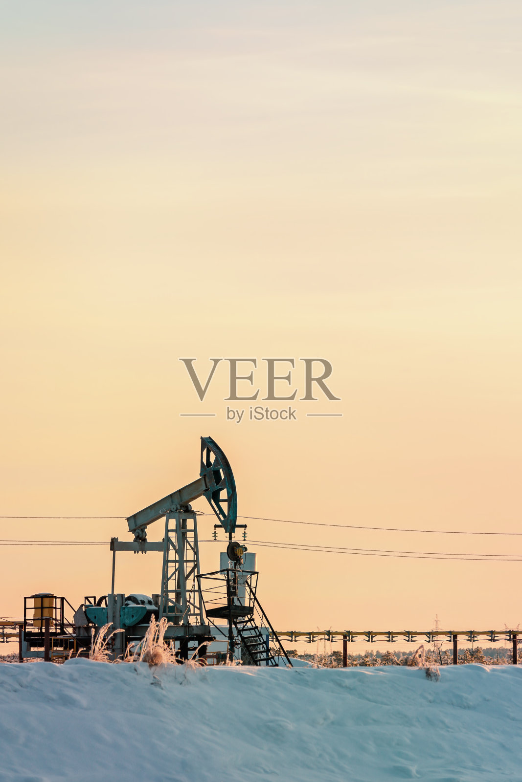 日落时，油泵从井中出油。照片摄影图片