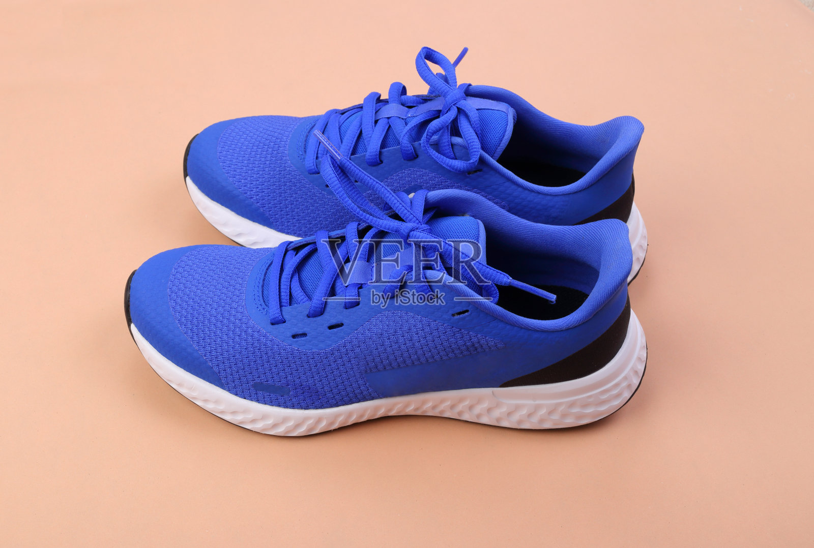 蓝色的跑鞋，粉红色的背景照片摄影图片