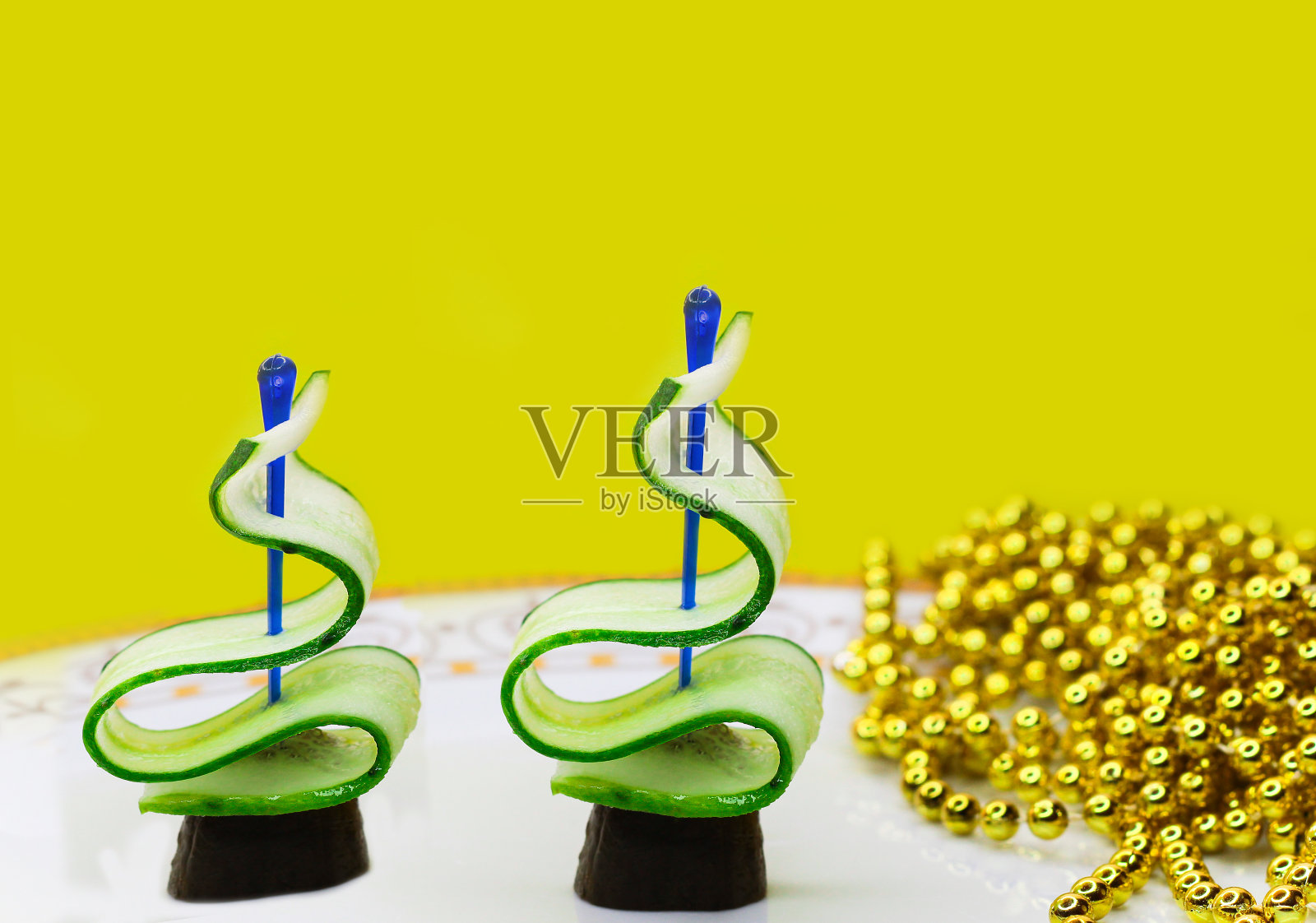 黄瓜树在白色的盘子和黄色的背景。照片摄影图片