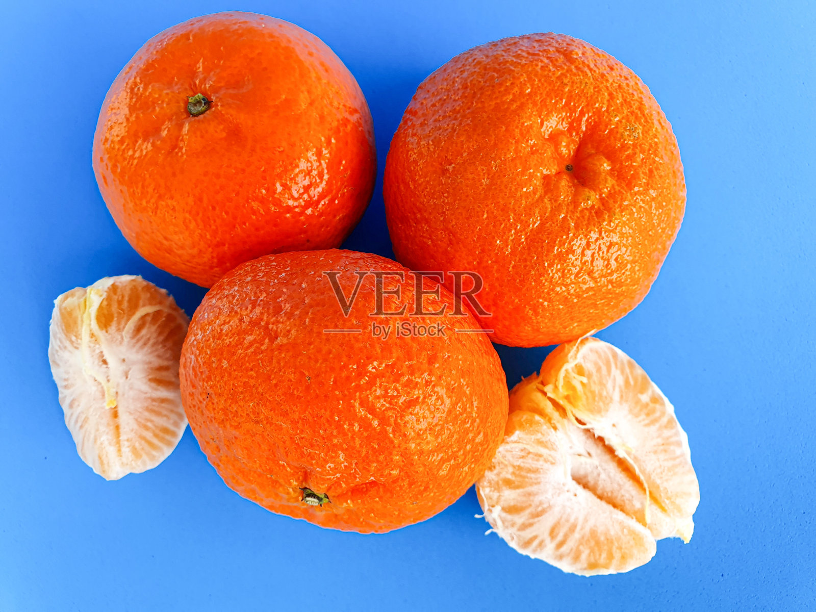 新鲜的普通话在蓝色背景。维生素。热带水果照片摄影图片