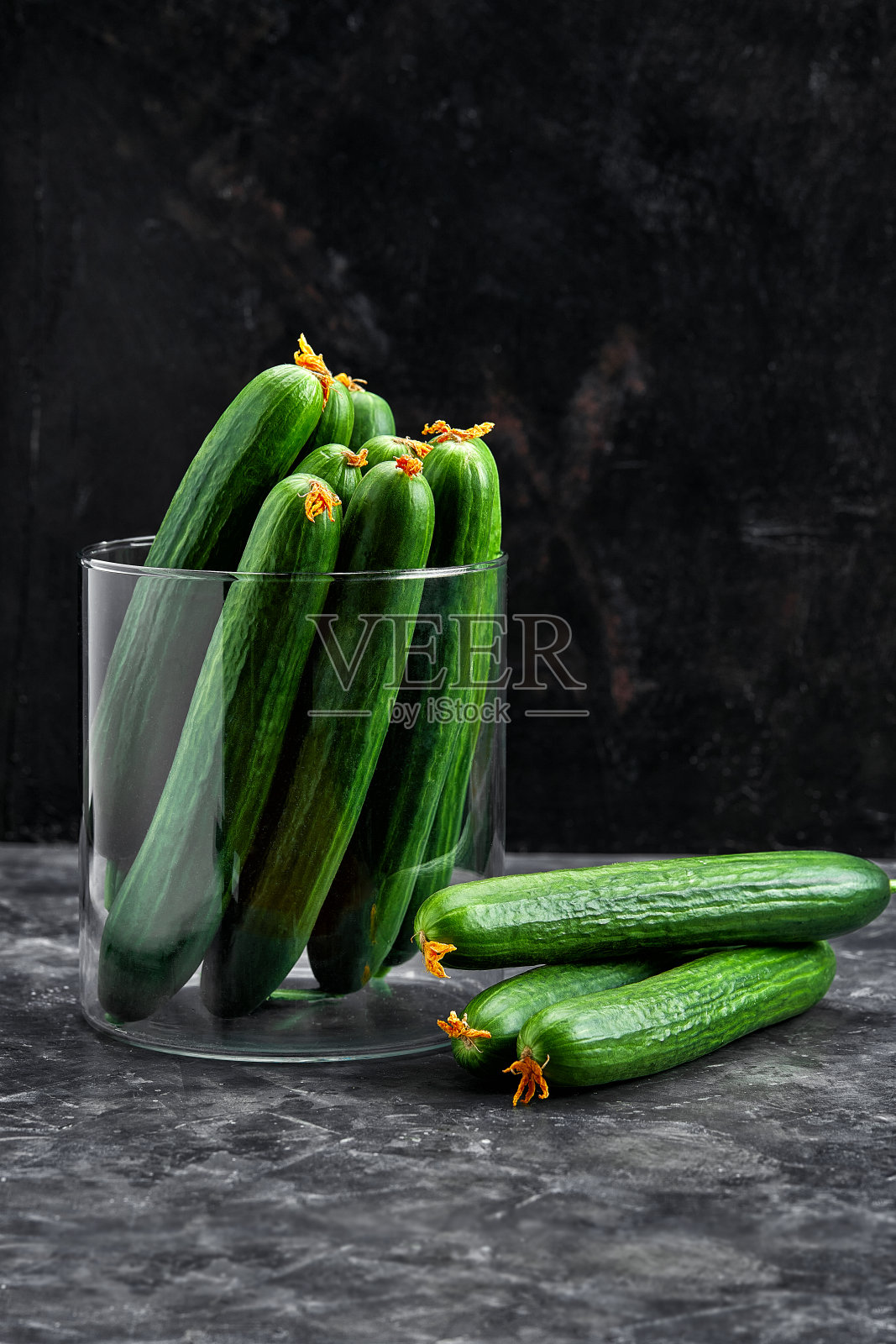 侧视图黄瓜在玻璃碗与复制空间在黑色的石头背景。交付的食物照片摄影图片
